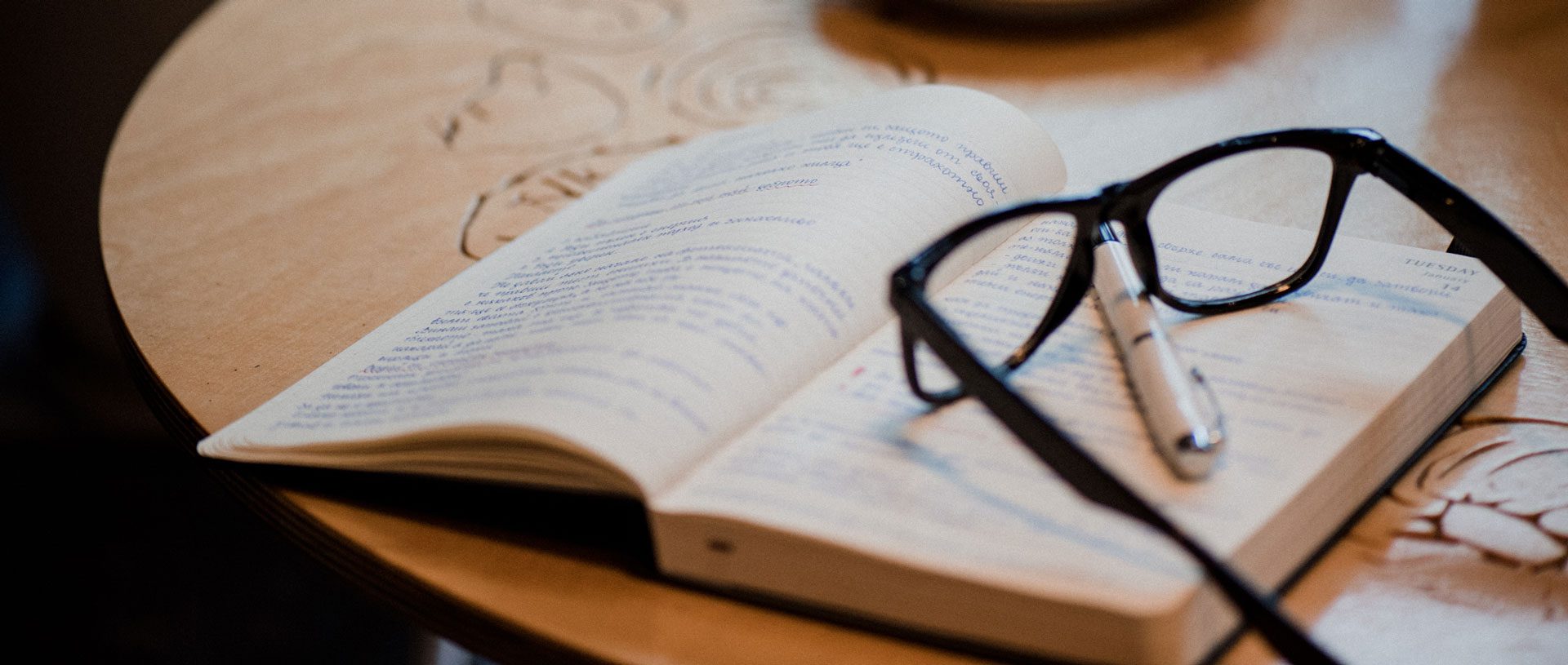 Open journal with pen and glasses on top